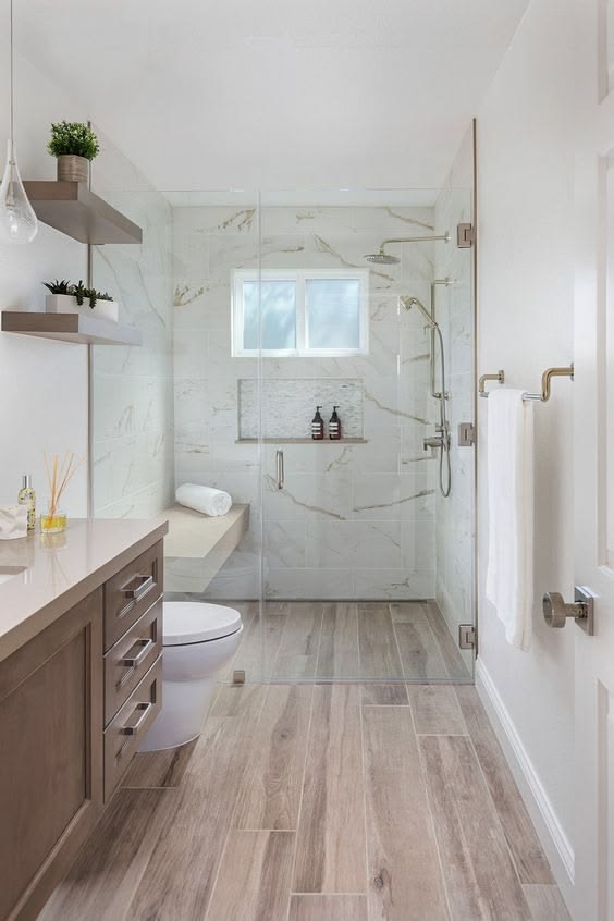 Renovated bathroom with glass shower enclosure and wood-look tile flooring