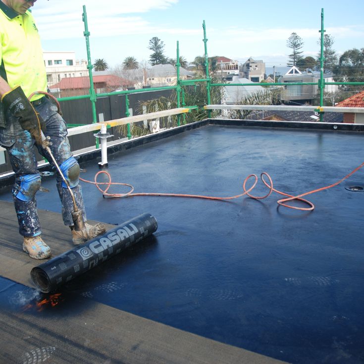 Torch-on waterproofing membrane being applied to a flat roof